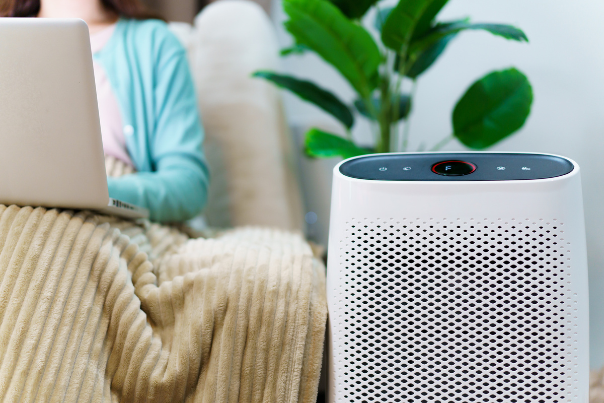 Woman using air purifier while stay in living room